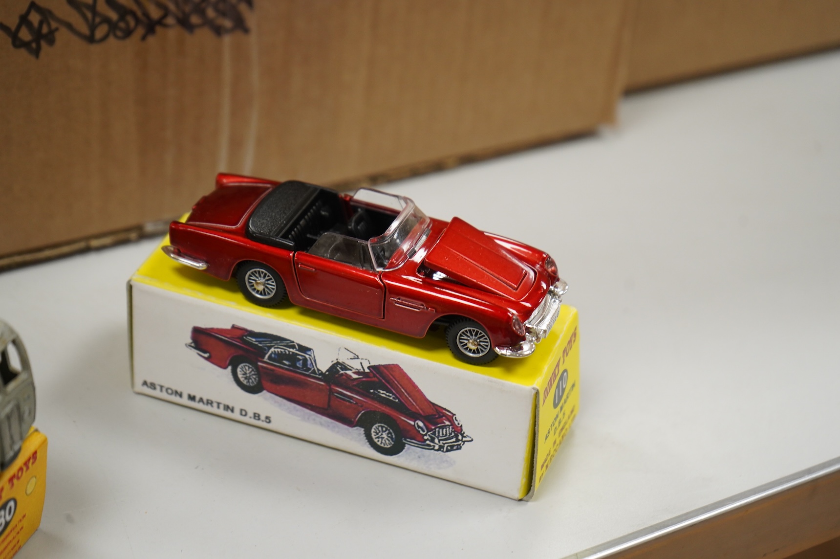 Thirty-two Dinky Toys, all playworn, restored, repainted or overpainted examples in reproduction boxes, including cars and light commercial vehicles